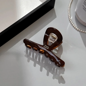 Detailed macro view of brown handmade hair claw clip with France handmade engraving
