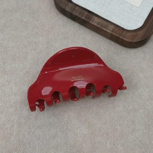Detail of red acetate hair claw clip with gold Barrette La France lettering