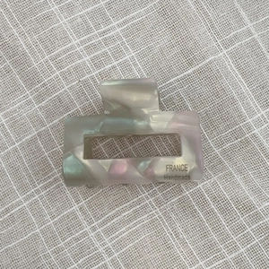 Detail view of small marble white acetate hair claw clip with pearlescent finish