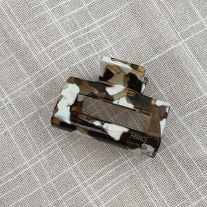 Detailed macro view of handmade French tortoiseshell acetate rectangle hair claw clip