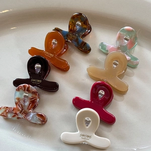 Set di 8 mollette piccole in acetato marmorizzato e ambrato su vassoio di ceramica bianca