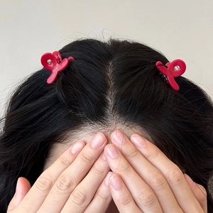 Set di due fermagli per capelli in acetato rosso per acconciature su una modella