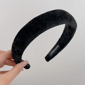 Detail showing the handmade label and plush velvet texture of this black hair accessory