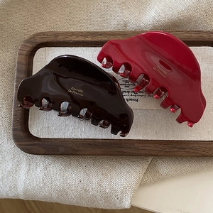 French vintage acetate hair claws in dark coffee and bright red on a wooden tray