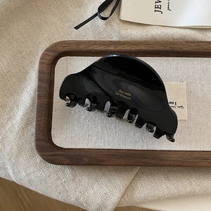 Close-up of black acetate hair claw clip with golden Barrette la France lettering