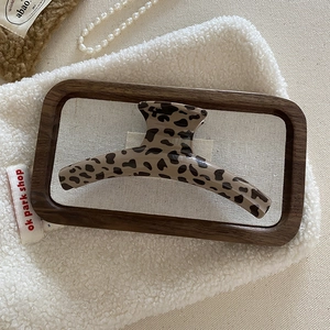 Macro shot of large leopard print hair claw clip on cozy winter fabric background