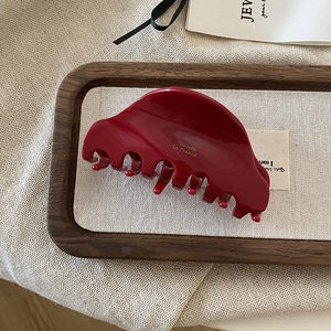 Detail of dark red acetate hair claw clip with gold Barrette La France text engraving