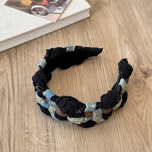 Detailed shot of denim braided headband with gold star embroidery on a wooden surface