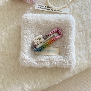 Detailed knit texture of a rainbow crochet hair clip with a cute bunny fabric label