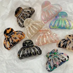 Nine French acetate pumpkin hair claws in assorted marble and tortoise patterns