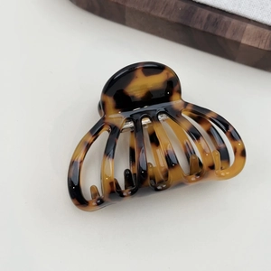 Detailed macro view of the tortoiseshell resin hair claw clip with a glossy finish