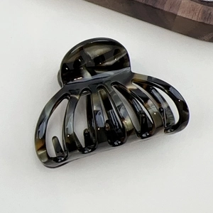 Macro view of tortoise shell acetate claw clip with polished marble texture for hair
