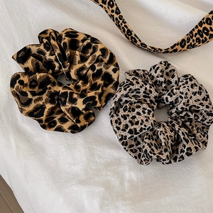 Detail of leopard print scrunchies in brown and grey fabric showing soft wavy textures