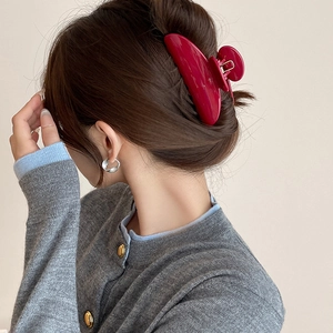 Elegant wine red hair claw clip shown on a model with minimalist silver hoop earrings