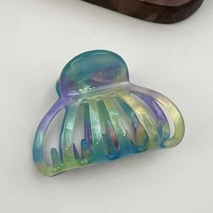 Macro view of gradient acetate pumpkin claw clip showing detailed iridescent texture and colors