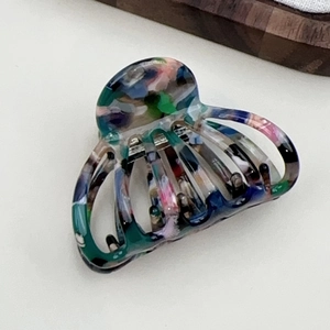 Detail of colorful acetate hair claw clip with marble texture and silver spring