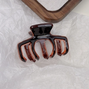 Detailed macro view of tortoiseshell acetate hair claw with gold France Handmade logo