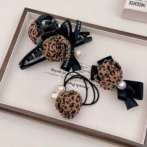 Leopard print hair accessory set with fabric roses and pearls in a wooden tray