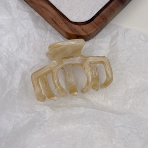 Detailed macro view of acetate hair claw clip with marble pattern and France lettering