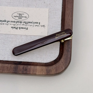Close-up of deep red acetate hair clip featuring gold Barrette la France lettering
