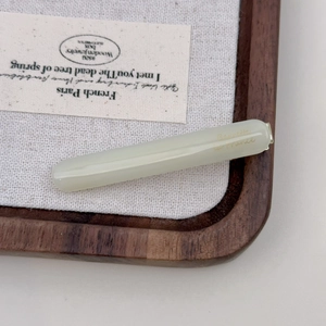 Detailed close-up of cream-white acetate hair clip with golden Barrette La France lettering