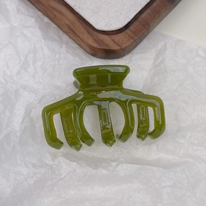 Detailed close-up of olive green acetate hair claw showing the France Handmade logo