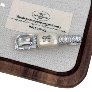 Elegant bow zircon hair clip with French style crystals on a vintage linen display