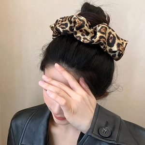 Chouchou oversize imprimé léopard en texture soie porté sur un chignon bas élégant