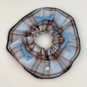 Close-up of blue and brown checkered scrunchie with cute denim bows and neat stitching