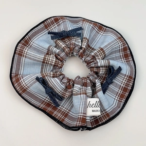 Detail of blue plaid fabric hair scrunchie with bows and high-quality stitching