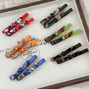 Chic acrylic bow hair clip set with marble patterns and French lettering on a tray