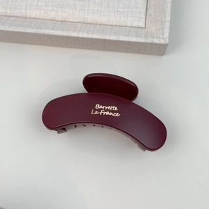 Detail of burgundy matte cloud hair claw clip with golden Barrette La France text