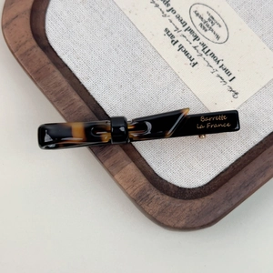 Close-up of tortoise shell barrette with Barrette La France text on wood tray