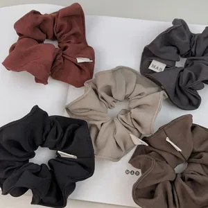 Five-piece set of minimalist large fabric scrunchies in neutral colors for ponytails