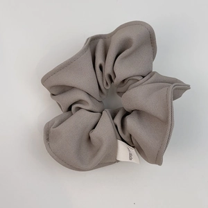 Handmade dark grey suit fabric scrunchie with detailed twill texture on white background