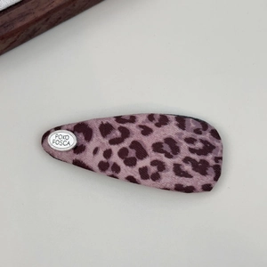 Detail view of pink leopard print fabric BB clip with silver logo and twill texture