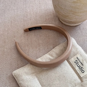 Handmade brown leather textured headband on a linen cloth with minimalist style decor