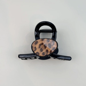 Macro view of black hair claw clip featuring a stylish leopard print oval buckle detail