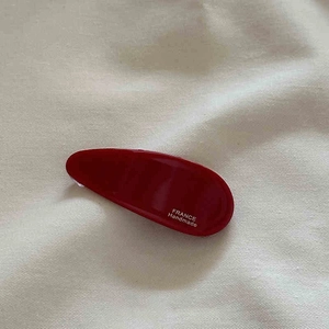 Détail d'une pince à cheveux rouge foncé faite main avec l'inscription France Handmade