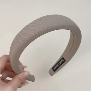 Detail of taupe sponge headband showing refined knitted texture and handmade label