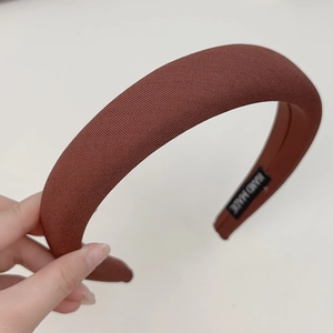 Close-up of brown ribbed sponge headband with handmade label showing fabric texture