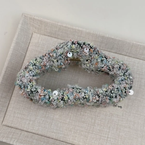 Détail de la grande pince à cheveux avec paillettes colorées et structure en métal doré