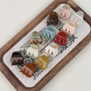 Mini acetate hair claws in 11 assorted colors on wooden tray French style hair clips