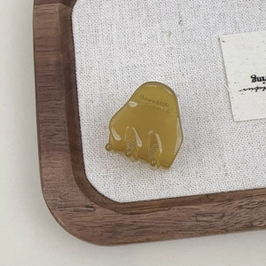 Detailed view of an amber yellow acetate hair claw clip with France golden logo lettering