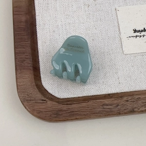 Macro view of blue acetate hair claw with Barrette la France gold lettering text
