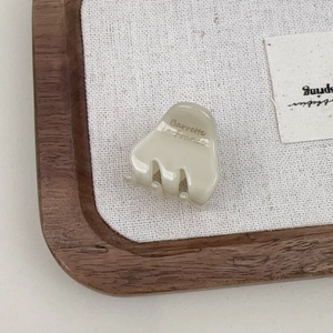 Detailed view of small cream acetate hair claw clip with golden Barrette La France lettering