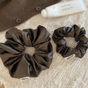 Ensemble d'élastiques à cheveux en satin marron café pour femme sur fond doux