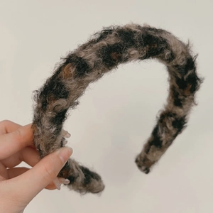 Detailed view of the fuzzy leopard print headband featuring plush faux fur texture