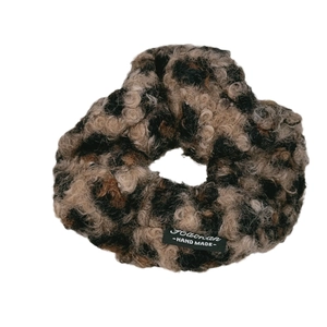 Leopard print faux fur scrunchie with handmade label on a clean white background