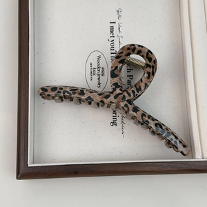Macro shot of French leopard print hair claw clip in a white decorative display box
